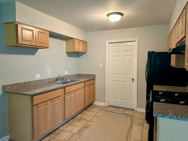 a kitchen with stainless steel appliances granite countertop a refrigerator and a sink