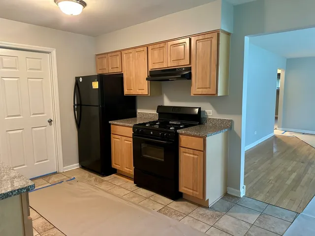 a kitchen with stainless steel appliances granite countertop a refrigerator a stove a sink and dishwasher