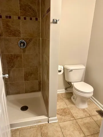 a bathroom with a toilet and a shower