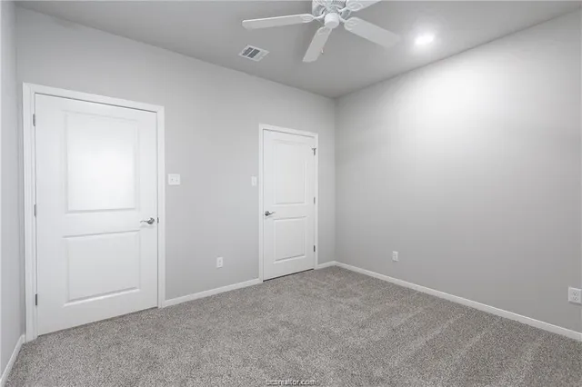 an empty room with a ceiling fan and a window
