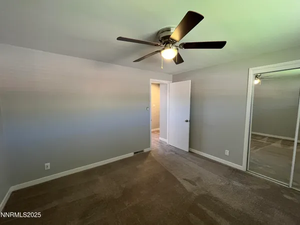 an empty room with closet and wooden floor