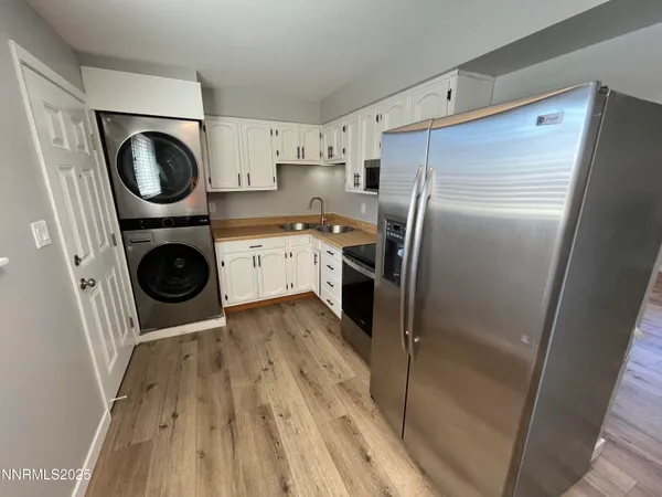 a kitchen with a refrigerator and washer dryer