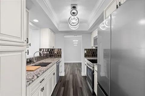a kitchen with a sink stainless steel appliances a counter top space and cabinets