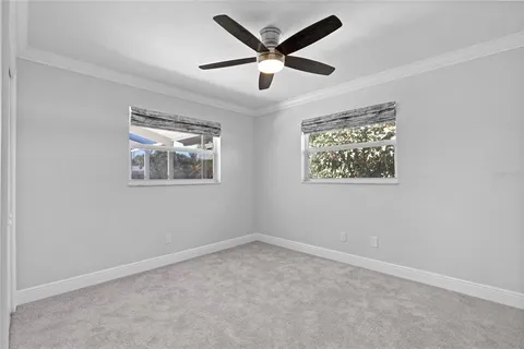 an empty room with wooden floor and ceiling fan