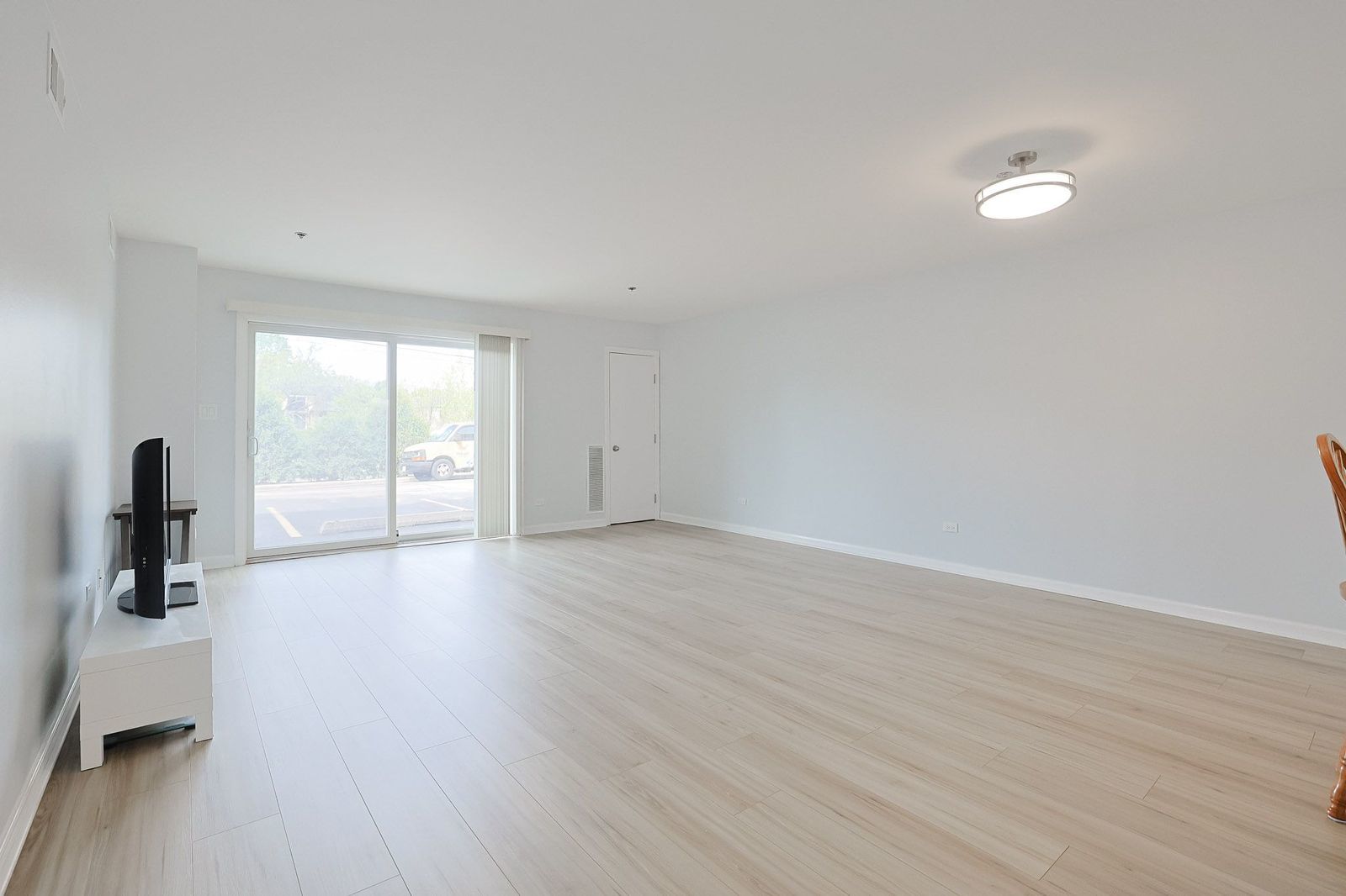 3265 Kirchoff Road, Unit 127 Rolling Meadows, IL 60008 - Photo 3 of 22 wooden floor in an empty room with a window