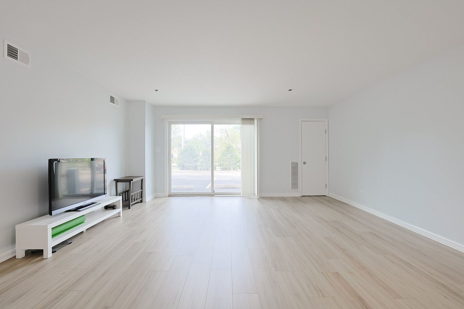 3265 Kirchoff Road, Unit 127 Rolling Meadows, IL 60008 - Photo 5 of 22 a view of an empty room with a window and a flat screen tv