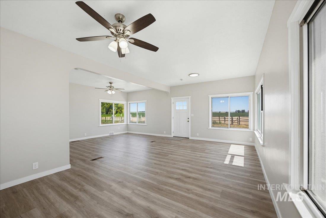 30013 Apple Valley Road Parma, ID 83660 - Photo 10 of 25 Spacious interior featuring wood-finish flooring, light gray walls, and multiple windows