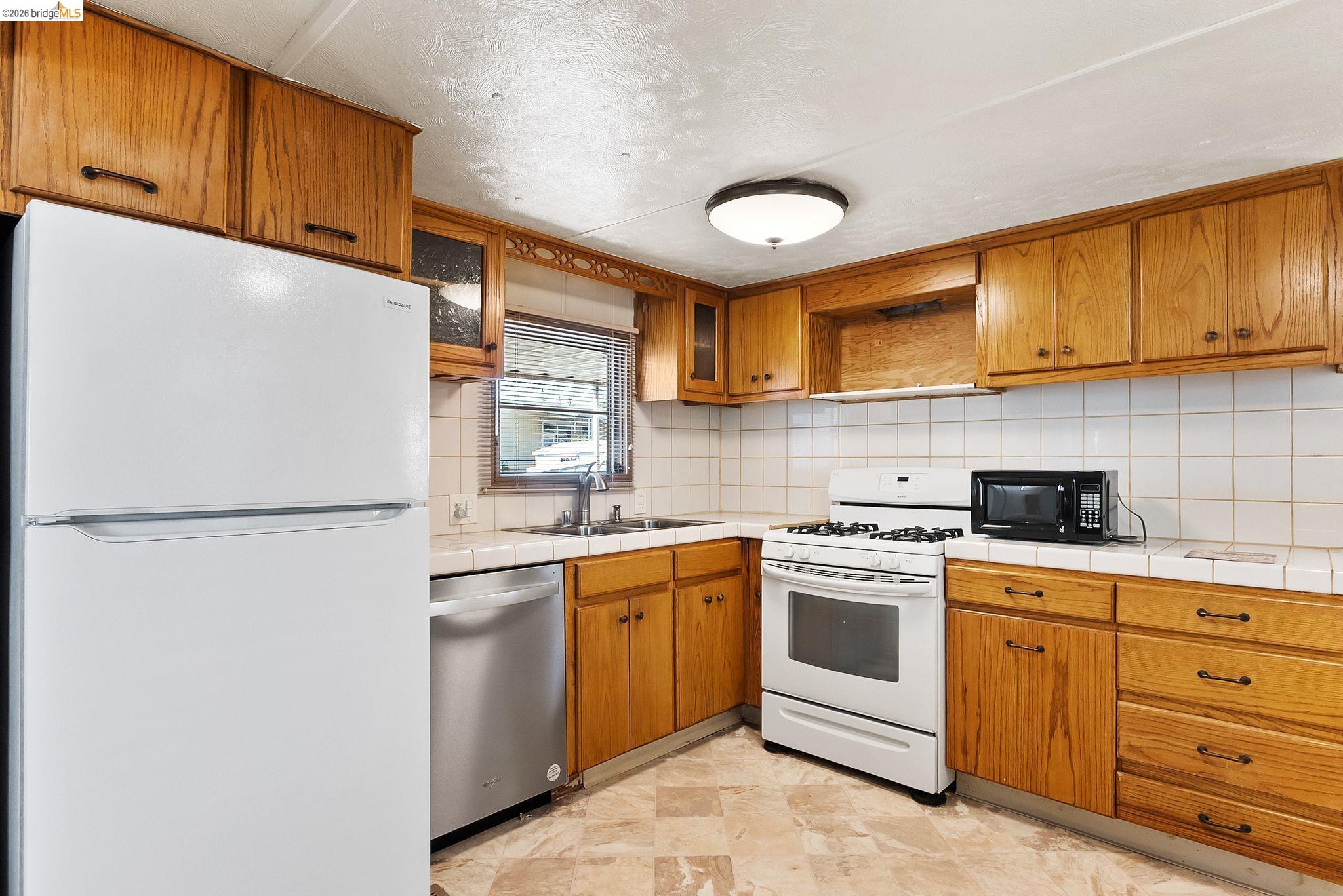 64 Oneida Street Oakley, CA 94561 - Photo 10 of 18 a kitchen with white cabinets and white appliances