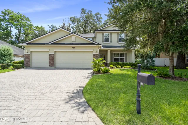 a front view of a house with a yard and trees