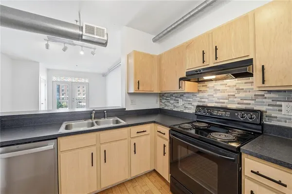 a view of an empty room with wooden floor