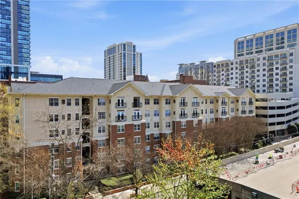 a view of a big room with wooden floor and windows