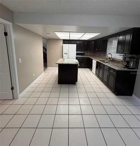 en empty room with windows and ceiling fan