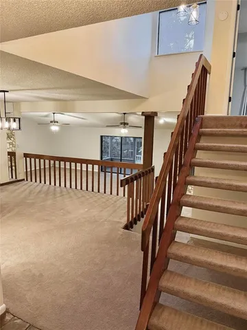 a view of staircase with lots of frames on wall and stairs