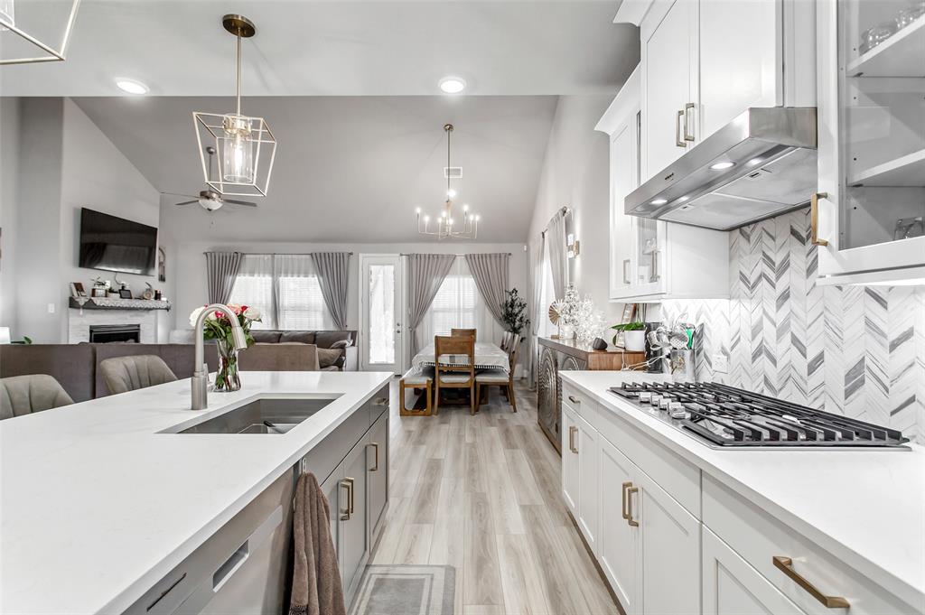 2437 Pinnacle Place Corinth, TX 76210 - Photo 12 of 40 a kitchen with a sink a stove and chairs