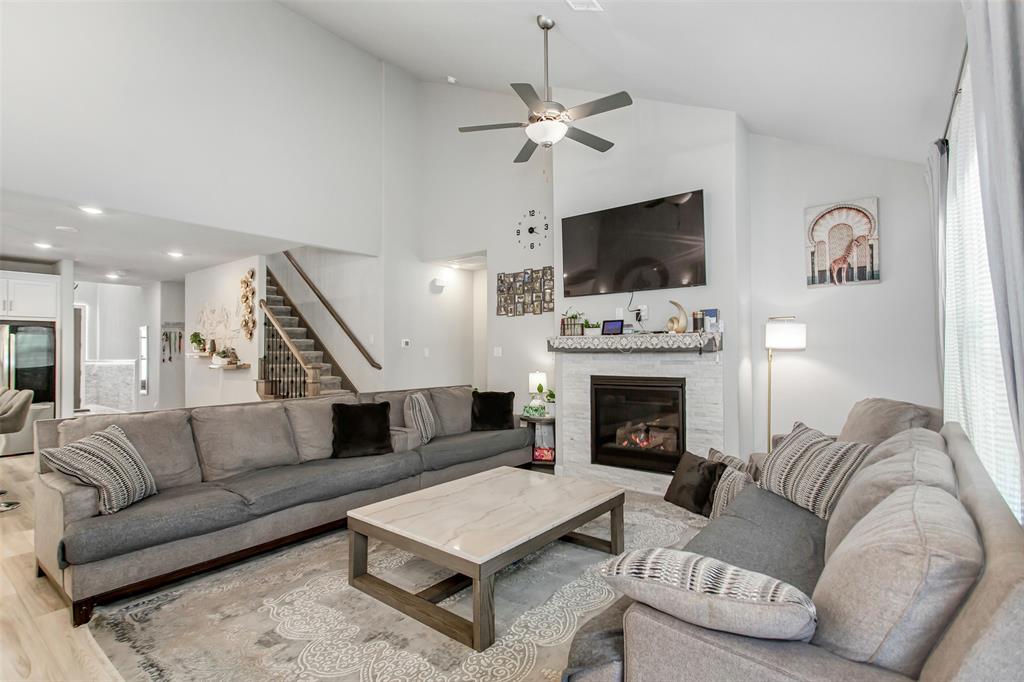 2437 Pinnacle Place Corinth, TX 76210 - Photo 16 of 40 a living room with furniture a flat screen tv and a fireplace