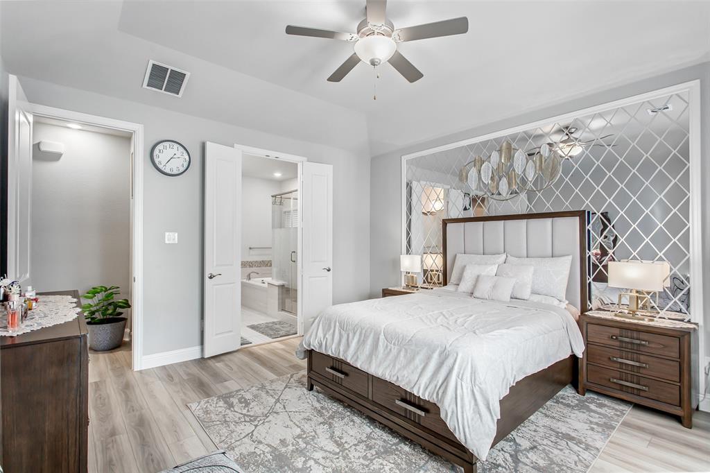 2437 Pinnacle Place Corinth, TX 76210 - Photo 20 of 40 a bedroom with a bed and a chandelier