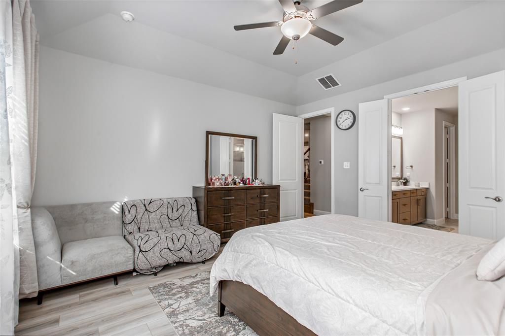 2437 Pinnacle Place Corinth, TX 76210 - Photo 21 of 40 a spacious bedroom with a bed a couch and dresser