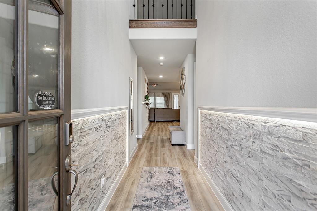 2437 Pinnacle Place Corinth, TX 76210 - Photo 3 of 40 a view of a hallway with wooden floor and staircase