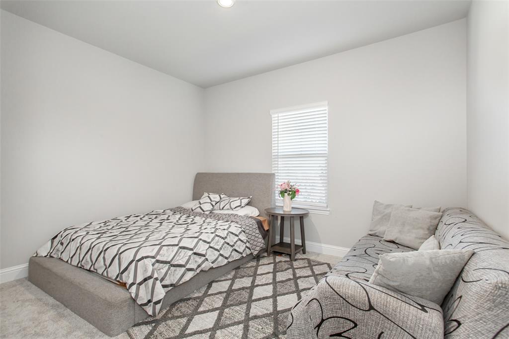 2437 Pinnacle Place Corinth, TX 76210 - Photo 5 of 40 a bedroom with a bed and a couch