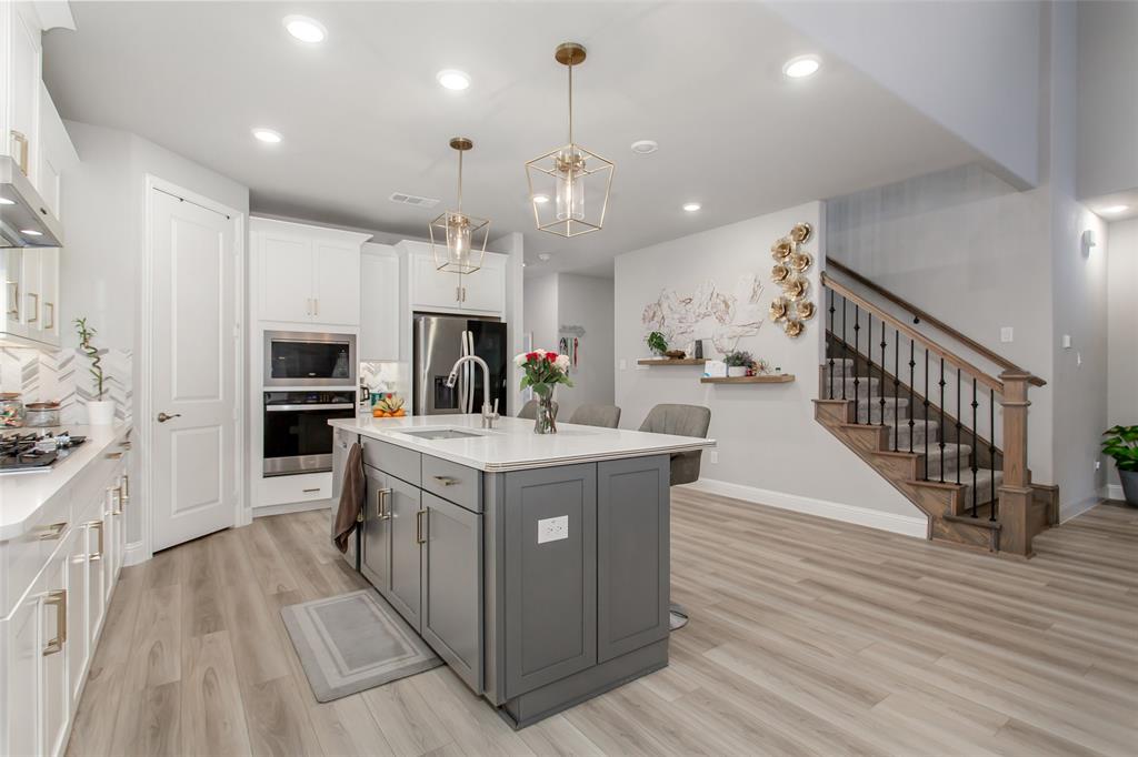 2437 Pinnacle Place Corinth, TX 76210 - Photo 10 of 40 a kitchen with stainless steel appliances granite countertop a lot of cabinets and wooden floor