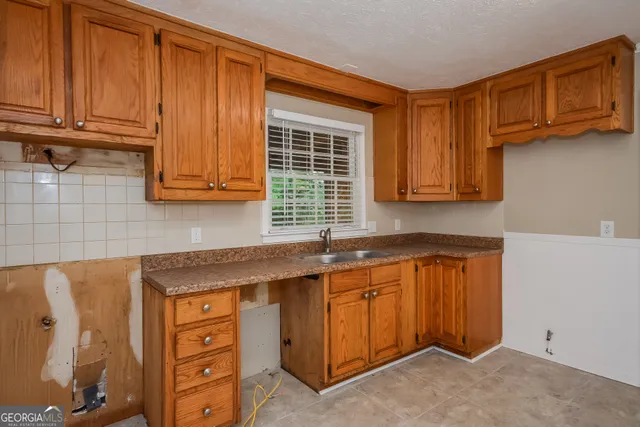 a kitchen with stainless steel appliances granite countertop wooden cabinets a sink and a window