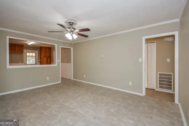 a view of an empty room with a ceiling fan and window