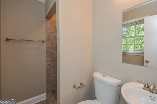 a white toilet sitting next to a bathroom sink