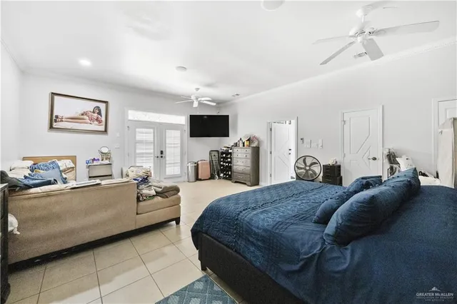 a large bedroom with a bed couches and flat screen tv