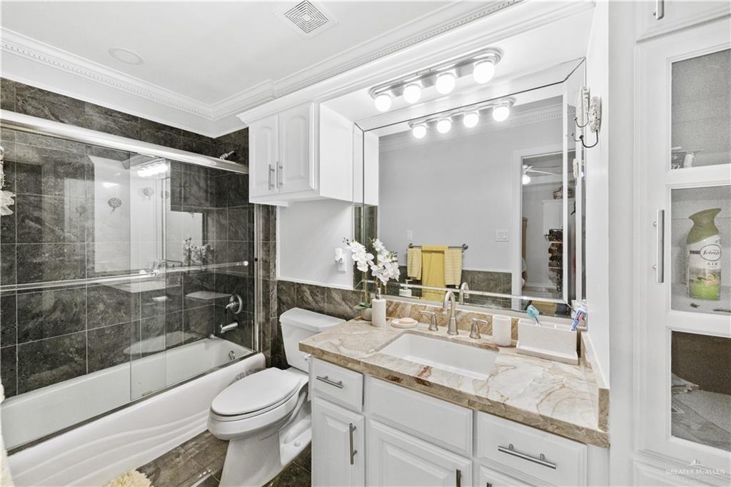 800 East Mile 3 Road Mission, TX 78573 - Photo 33 of 45 a bathroom with a granite countertop sink a toilet a mirror and shower