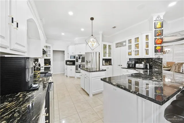 a large kitchen with stainless steel appliances granite countertop a lot of counter space and a sink