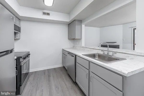 a kitchen with a sink cabinets and wooden floor