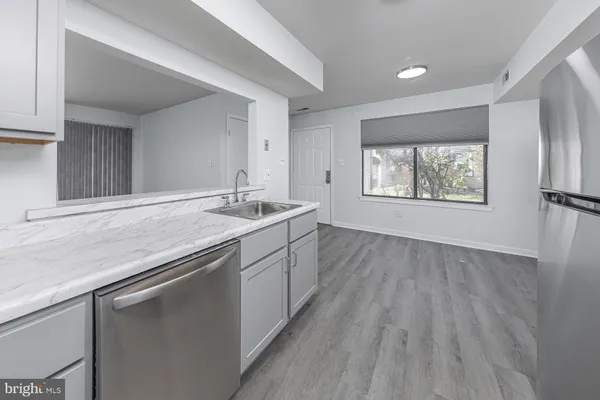 a kitchen with stainless steel appliances granite countertop a sink dishwasher a stove refrigerator and cabinets