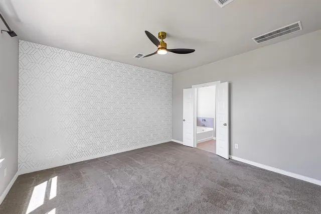an empty room with a ceiling fan and a window