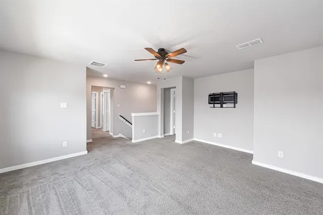 an empty room with a window and a fan