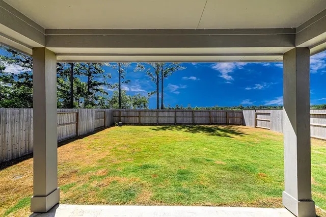 a view of house with backyard and seating area