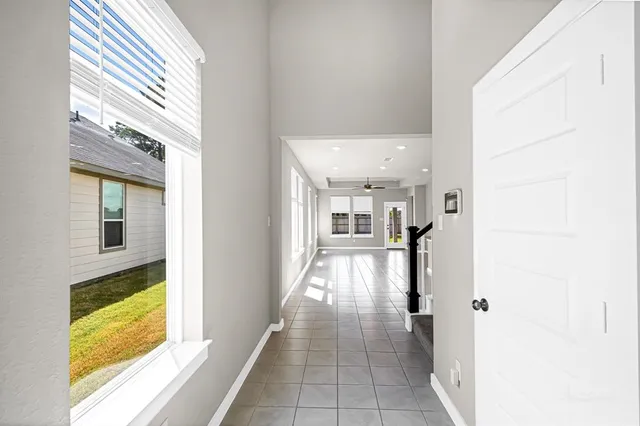 a view of a hallway with wooden floor and windows