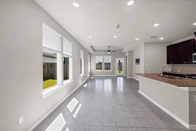a living room with stainless steel appliances furniture and a kitchen view