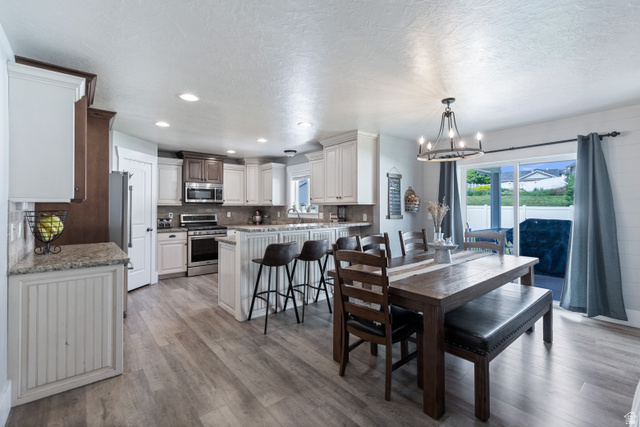 580 Cherry Ridge Lane Richmond, UT 84333 - Photo 10 of 53 Dining room with hanging lights, plenty of natural light, light wood-style floors, and a textured ceiling