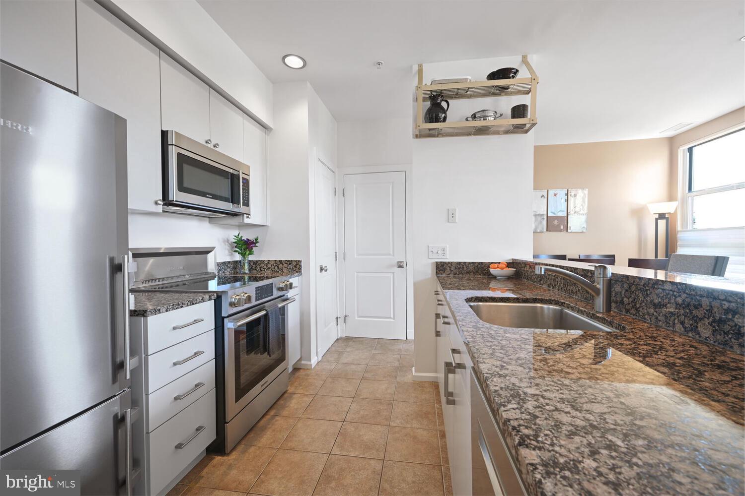 343 Cedar Street Northwest, Unit 322 Washington, DC 20012 - Photo 13 of 40 a kitchen with stainless steel appliances granite countertop a sink stove and refrigerator