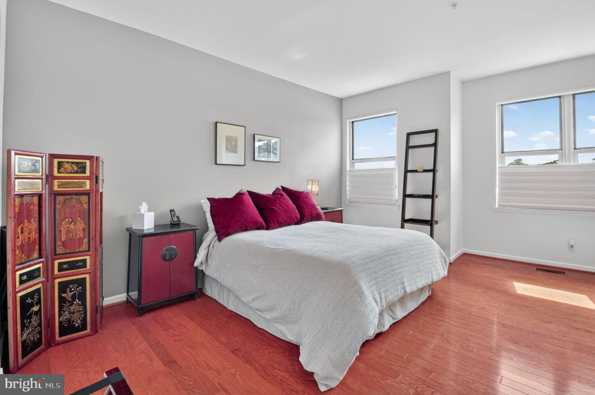 343 Cedar Street Northwest, Unit 322 Washington, DC 20012 - Photo 23 of 40 a bedroom with a bed and wooden floor