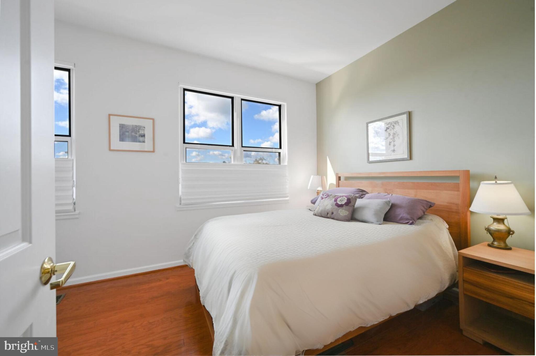 343 Cedar Street Northwest, Unit 322 Washington, DC 20012 - Photo 29 of 40 a bedroom with a bed and wooden floor