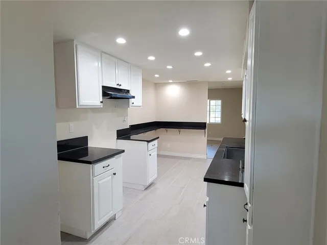 a kitchen with a sink and white cabinets