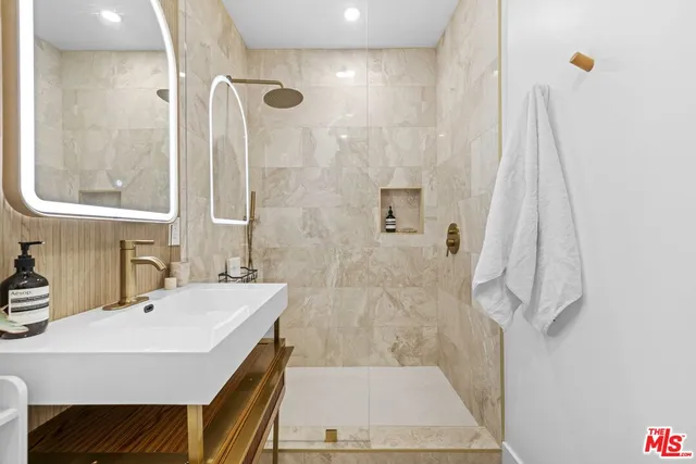 a bathroom with a sink a mirror and a shower