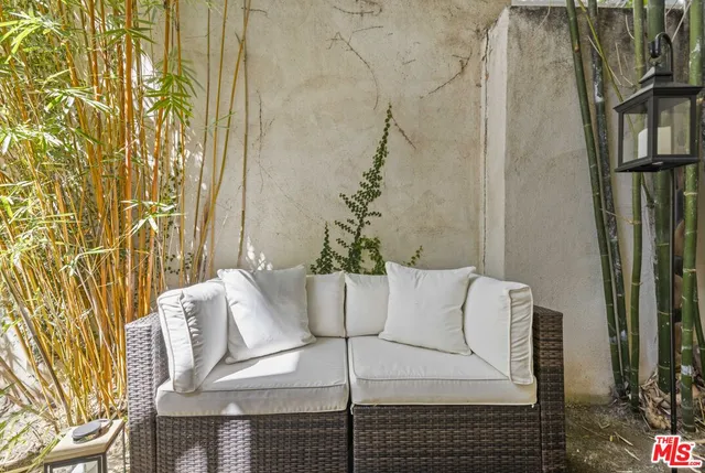 a view of a balcony with furniture and a potted plant