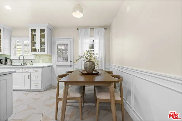 a kitchen with a table chairs sink and cabinets