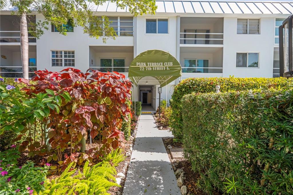72 7th Street South, Unit 108 Naples, FL 34102 - Photo 17 of 22 a front view of a house with a garden