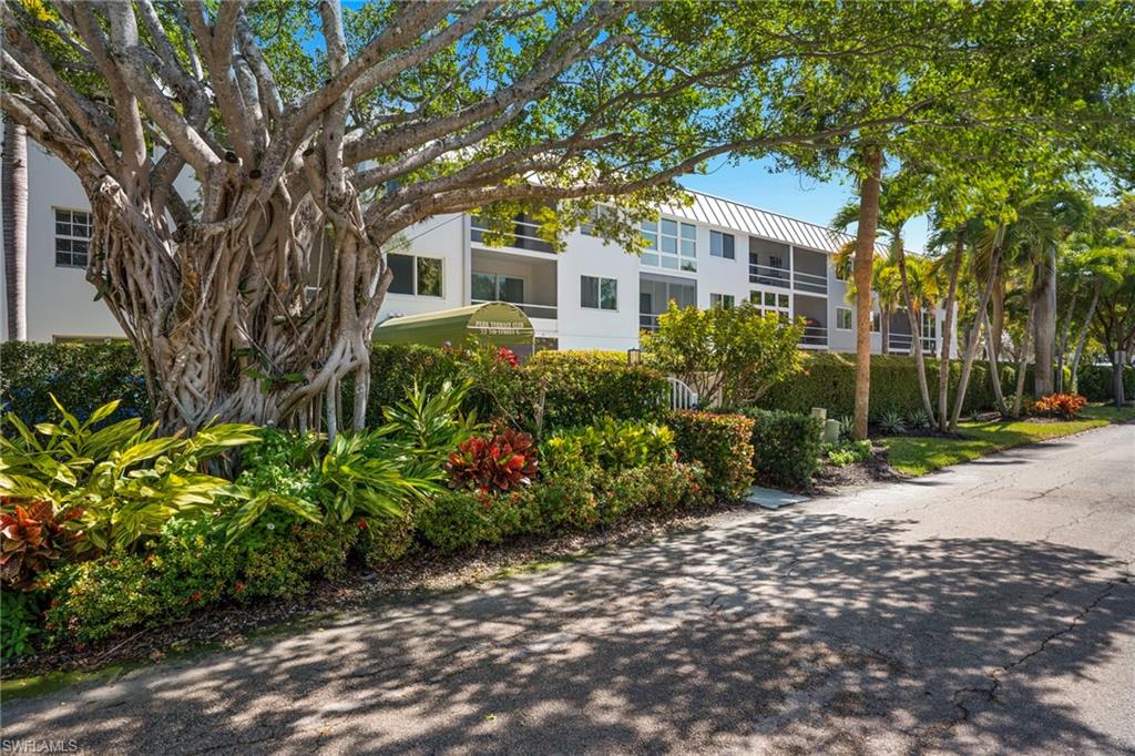 72 7th Street South, Unit 108 Naples, FL 34102 - Photo 19 of 22 a front view of a house with a garden