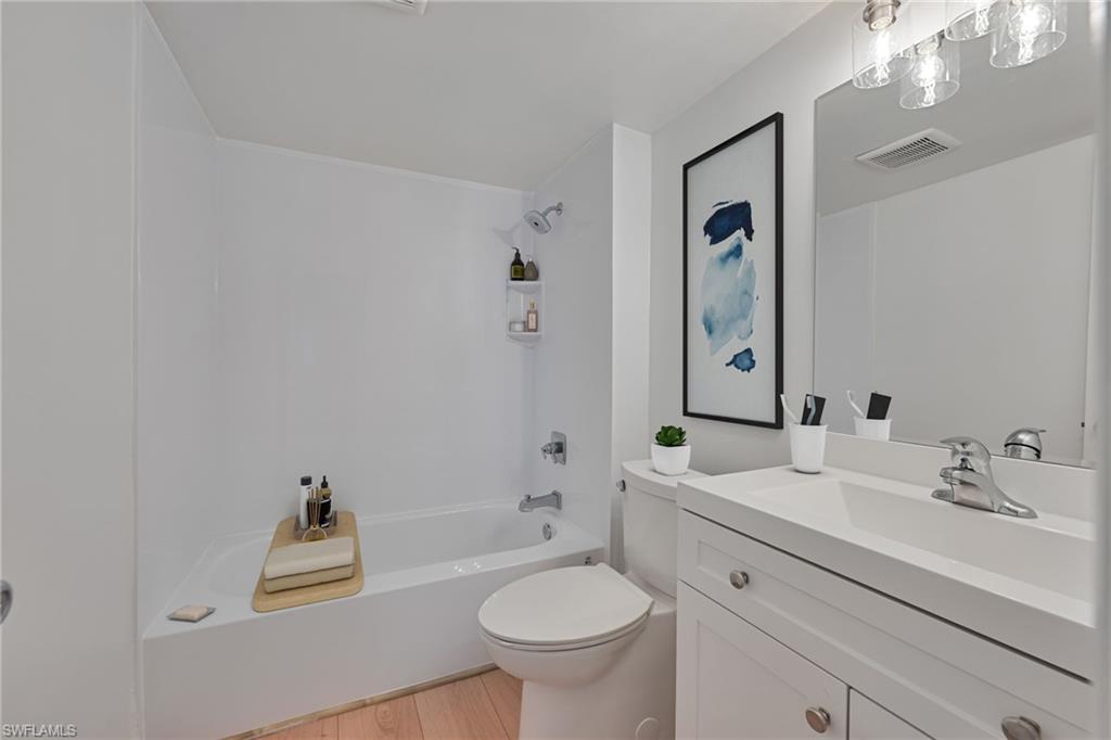 72 7th Street South, Unit 108 Naples, FL 34102 - Photo 5 of 22 a bathroom with a sink a toilet and a mirror