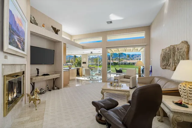 a living room with furniture large window and a flat screen tv