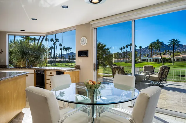 a dining room with furniture and a floor to ceiling window